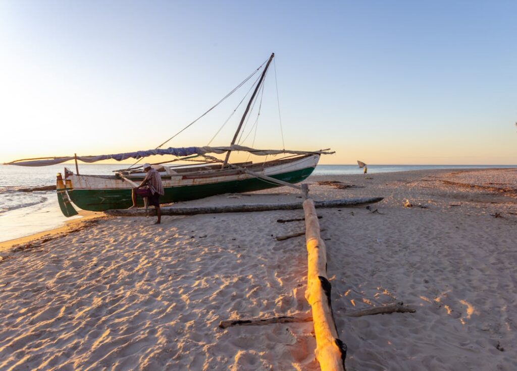 Plage de Nosy Be avec bateau traditionnel malgache au coucher du soleil